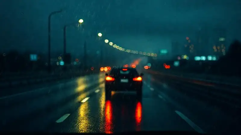 La carretera mojada refleja una ciudad oscura